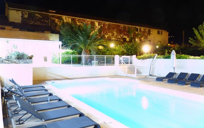 Buitenzwembad en ligbedden bij Hotel U Ricordu op Corsica
