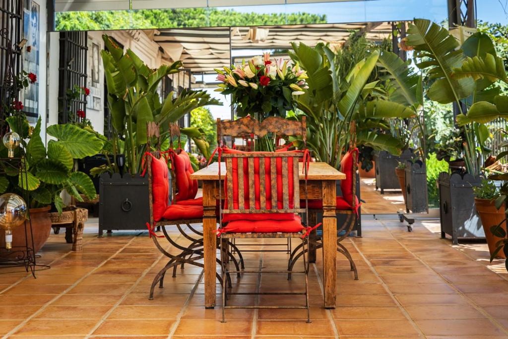 Cortijo Boutique Marbella - pergola met rode stoelen