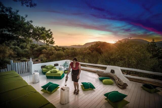 Su Gologone Experience Hotel - terras met loungekussens bij zonsondergang