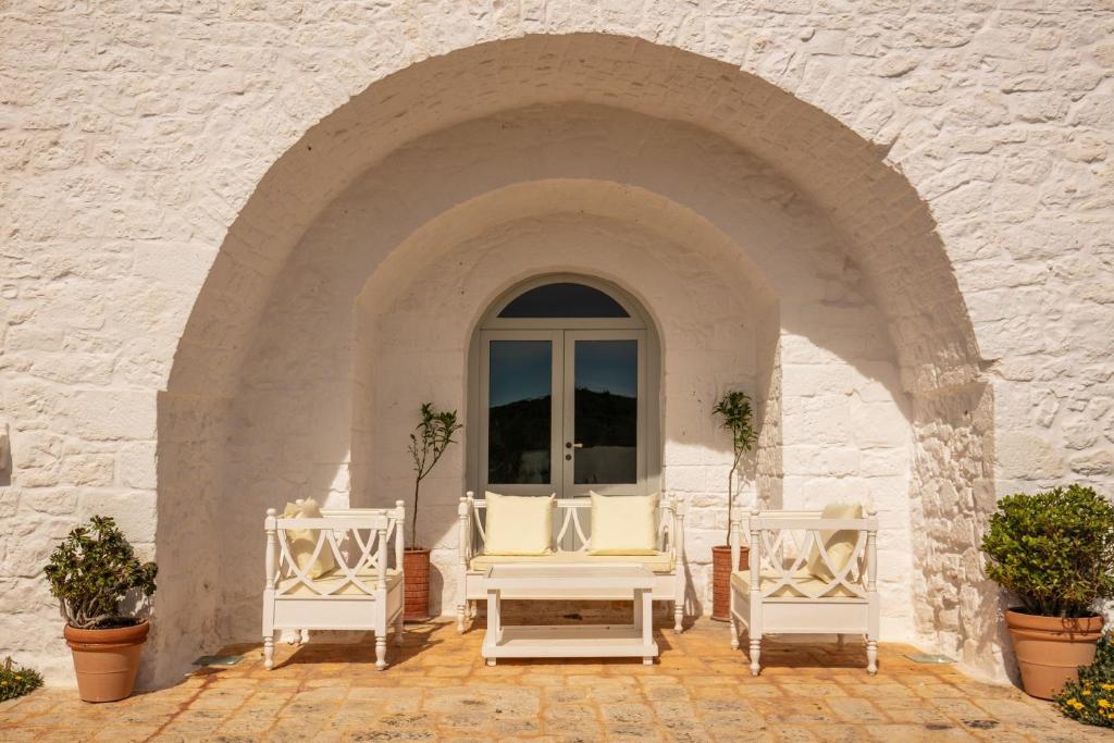 Masseria Cervarolo - bankjes onder de witte boog