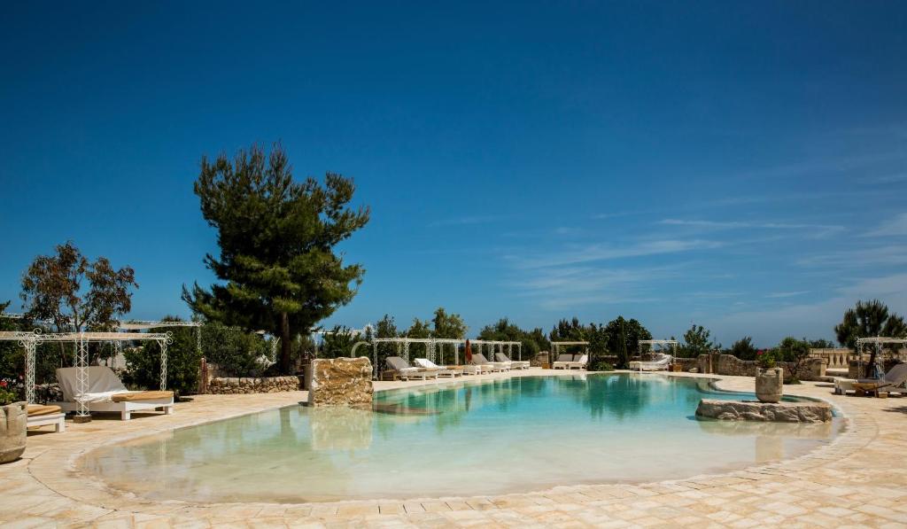 Masseria Montenapoleone - zwembad met ligbedden in de tuin
